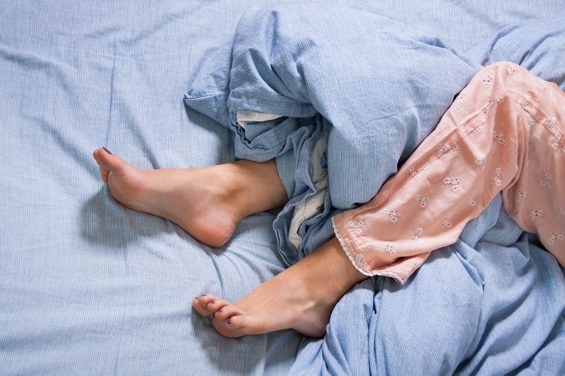 Person in Bed with Restless Legs Syndrome
