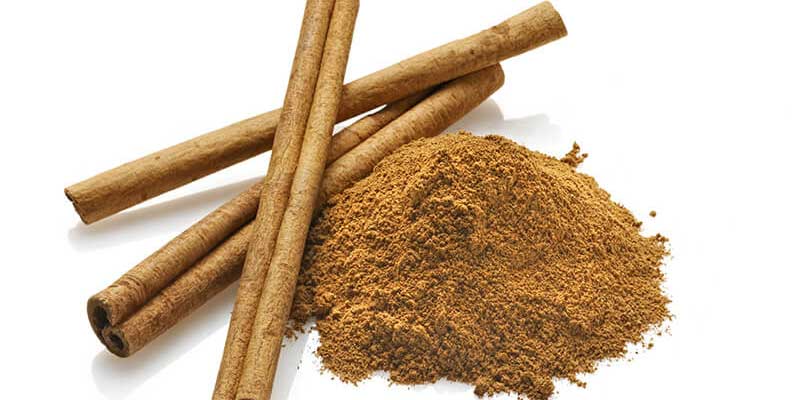 An image of fresh ground cinnamon and cinnamon sticks