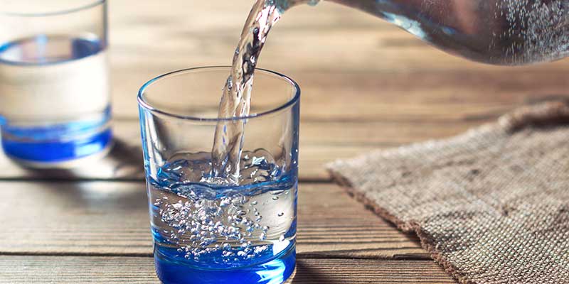 An image of a glass of water being poured from a pitcher