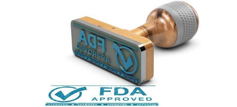 An ink stamp that says FDA Approved sits on its side